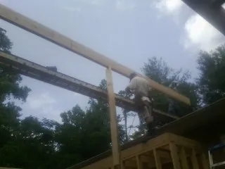 Carpenter setting a ridge beam over a new addition frame — Ice Dam Removal by Roofing Brothers in Fisherville