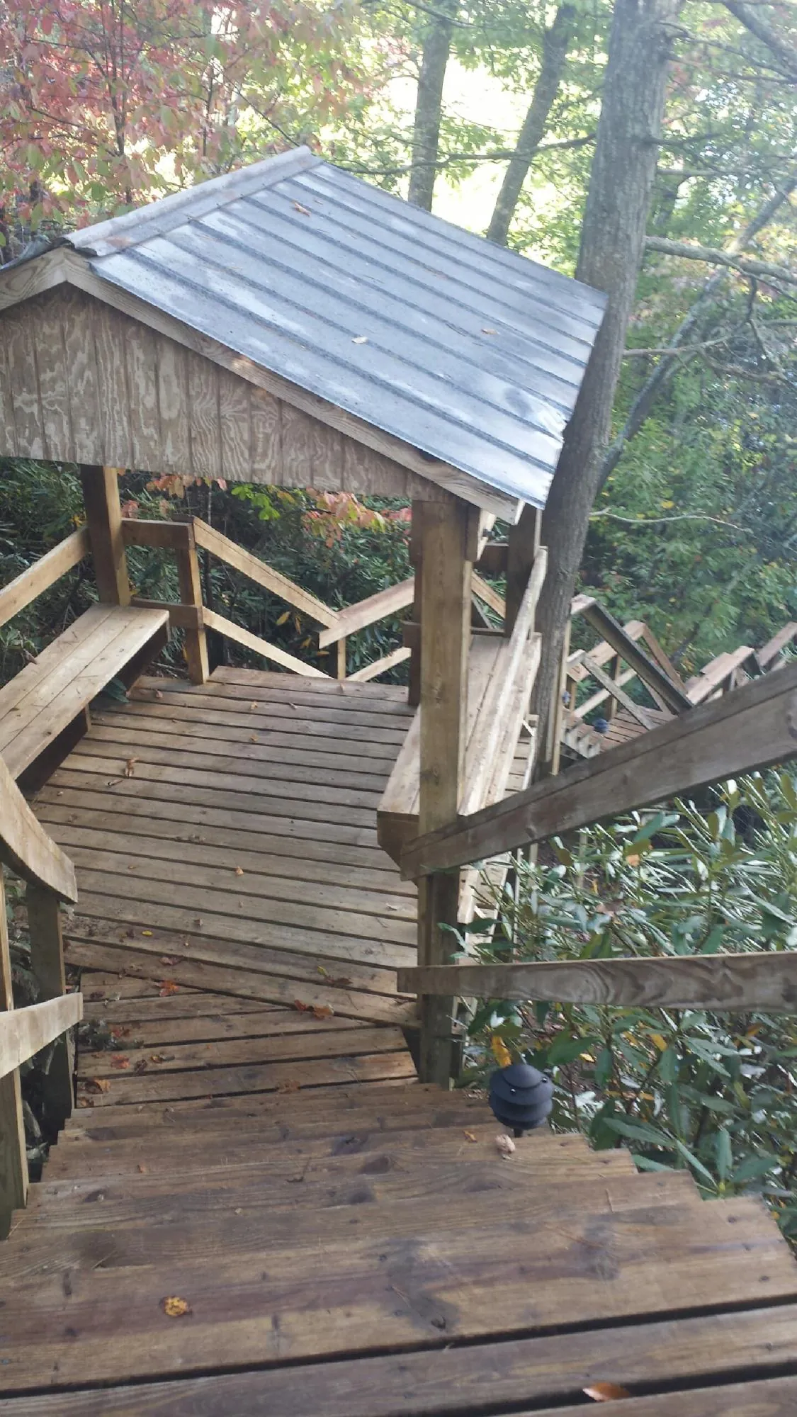 Metal roofed shelter over wooden steps on a wooded walkway — Skylight Repair & Installation work by our crew in Fisherville