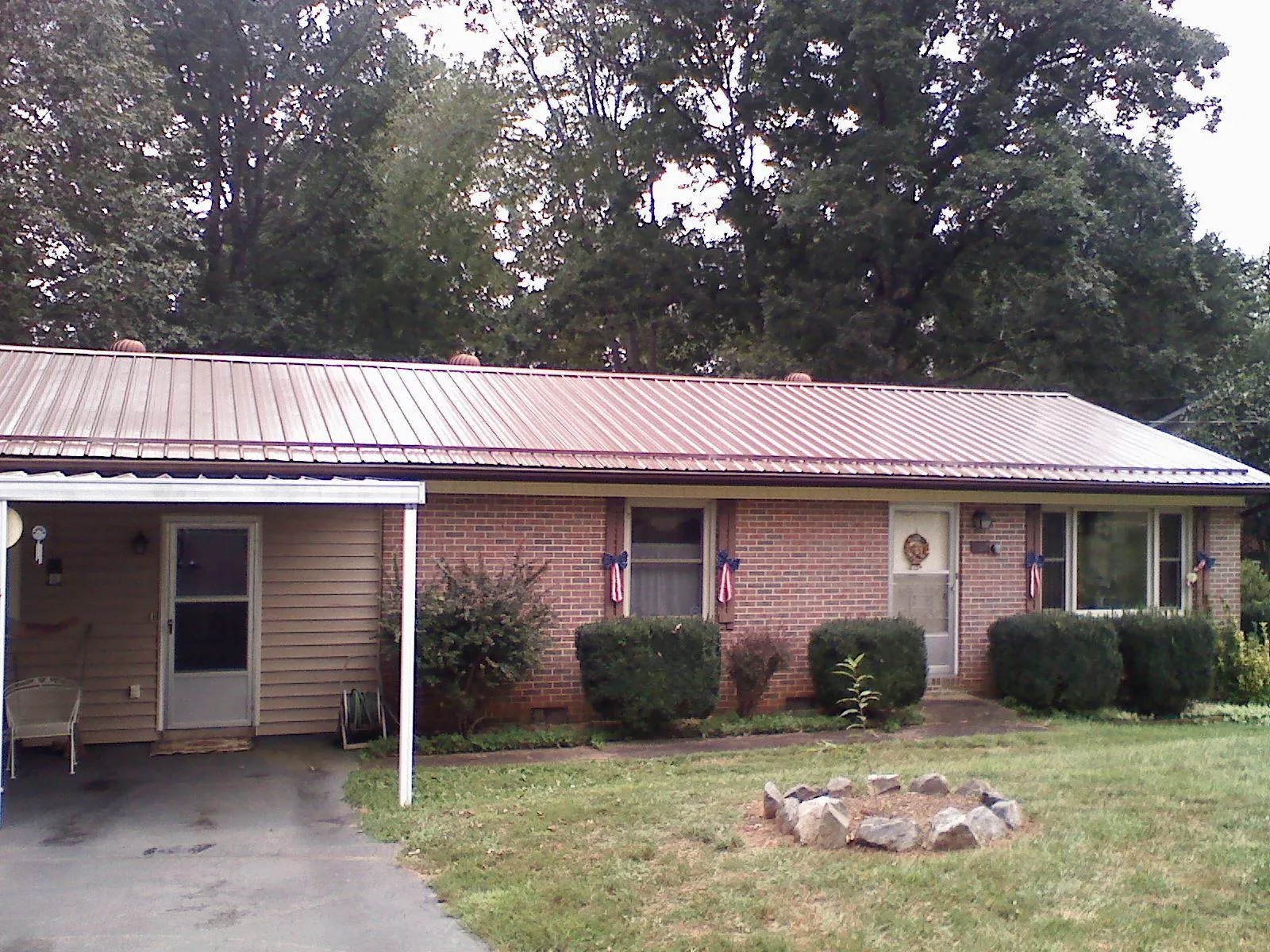 Bronze metal roof and carport on a brick ranch home — Roof Repair work by our crew in Fisherville